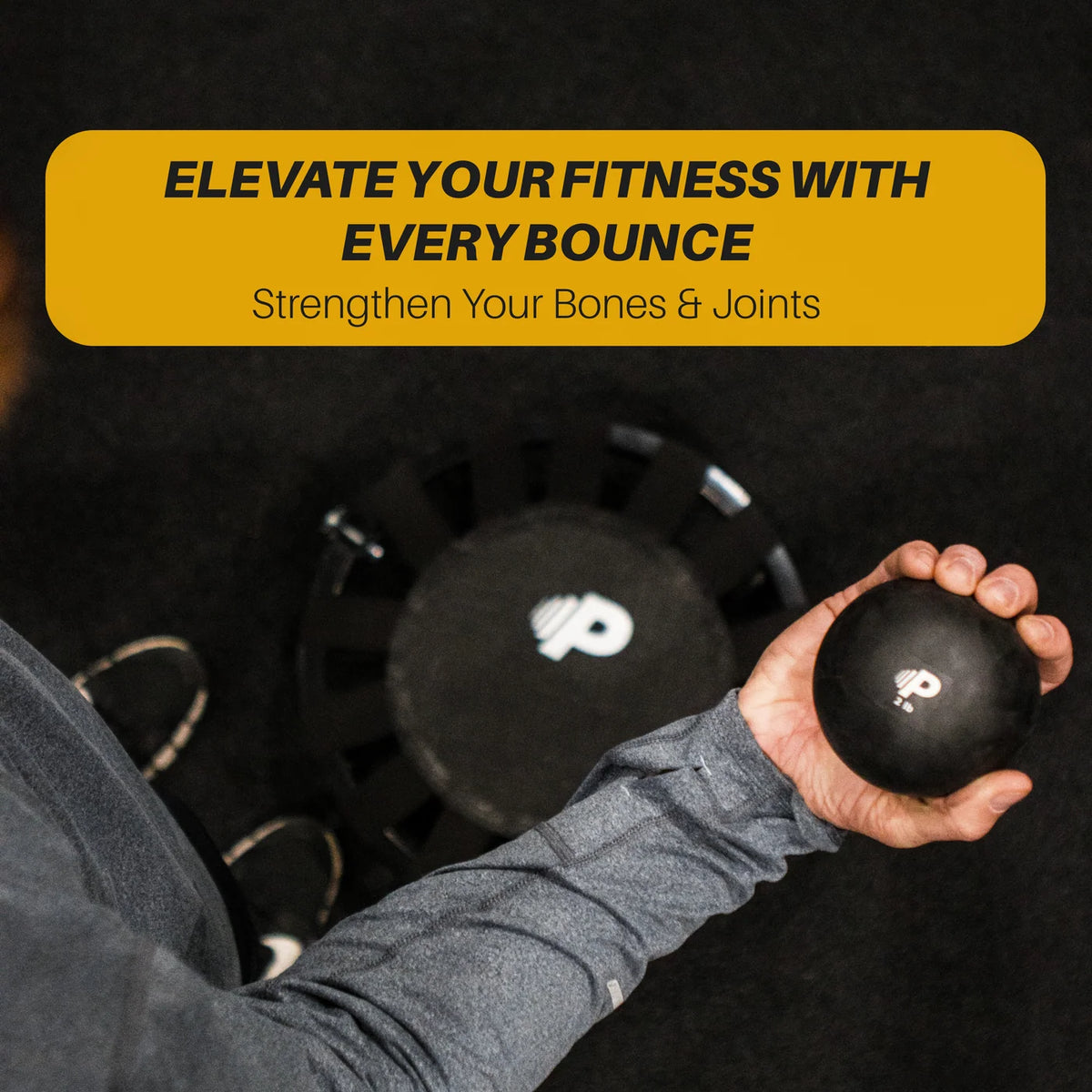 Person holding a black 'P' branded exercise ball with a mini rebounder in the background. Text reads: 'Elevate Your Fitness With Every Bounce – Strengthen Your Bones & Joints.