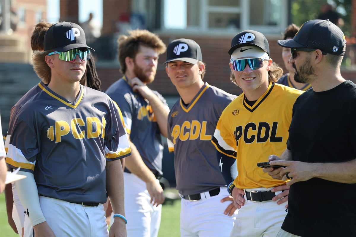 PCDL players in league jerseys gathered with a coach before a game